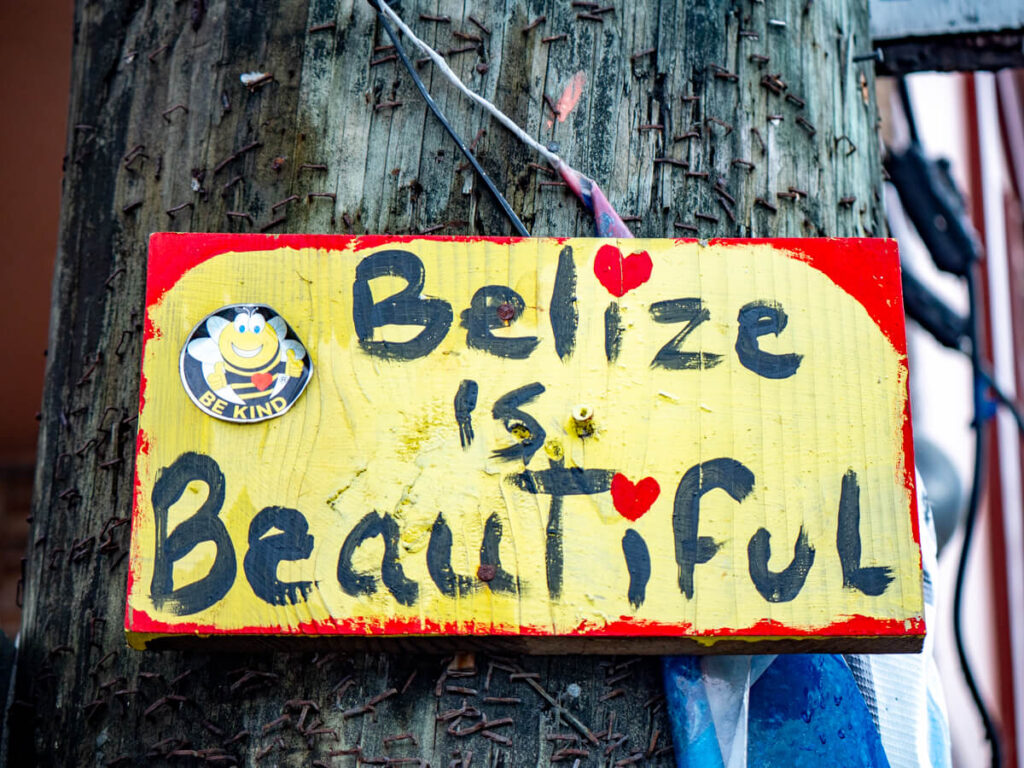 A handpainted yellow and red sign that reads Belize is beautiful.
