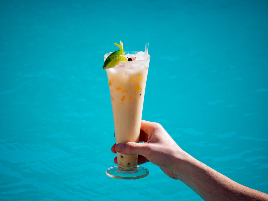 A cocktail in front of clear blue waters.