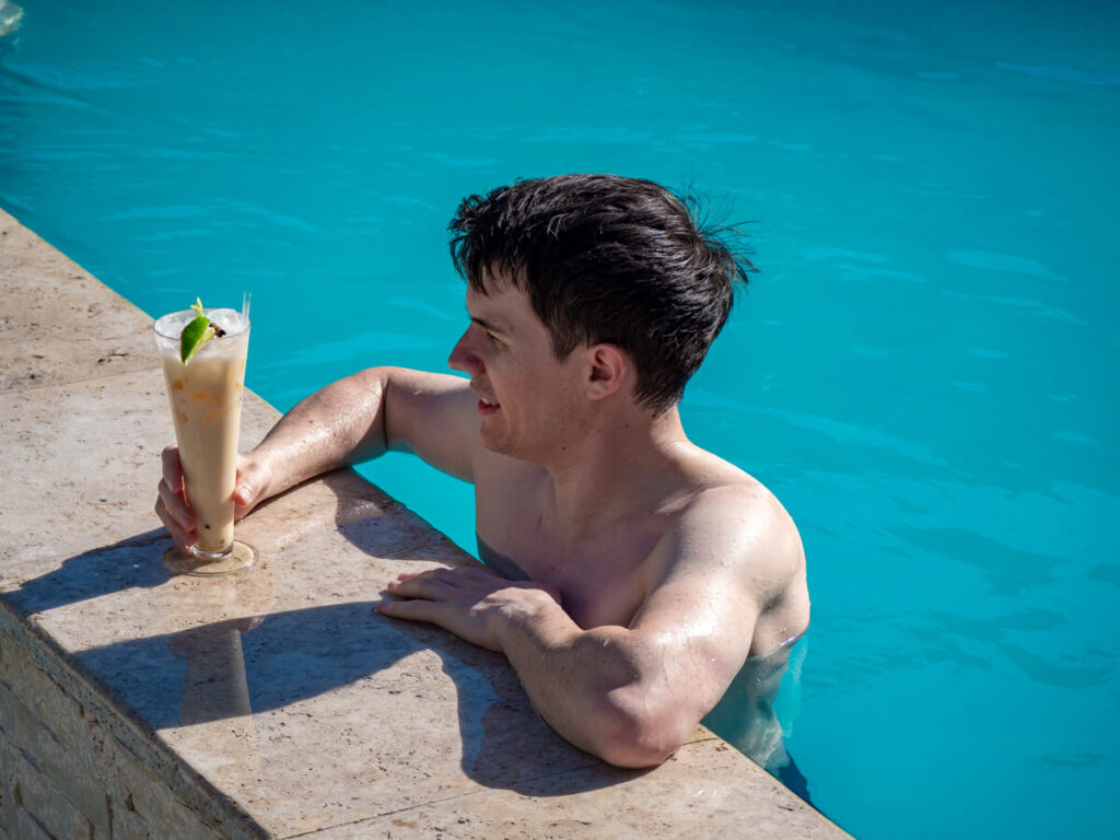 Dan relaxing in the pool at Belizean Shores Resort with a cocktail in his hand.