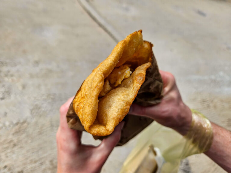 A breakfast fry jack, traditional in Belize, consisting of a donut-style dough that is deep-fried and then stuffed, with eggs, cheese, and beans.