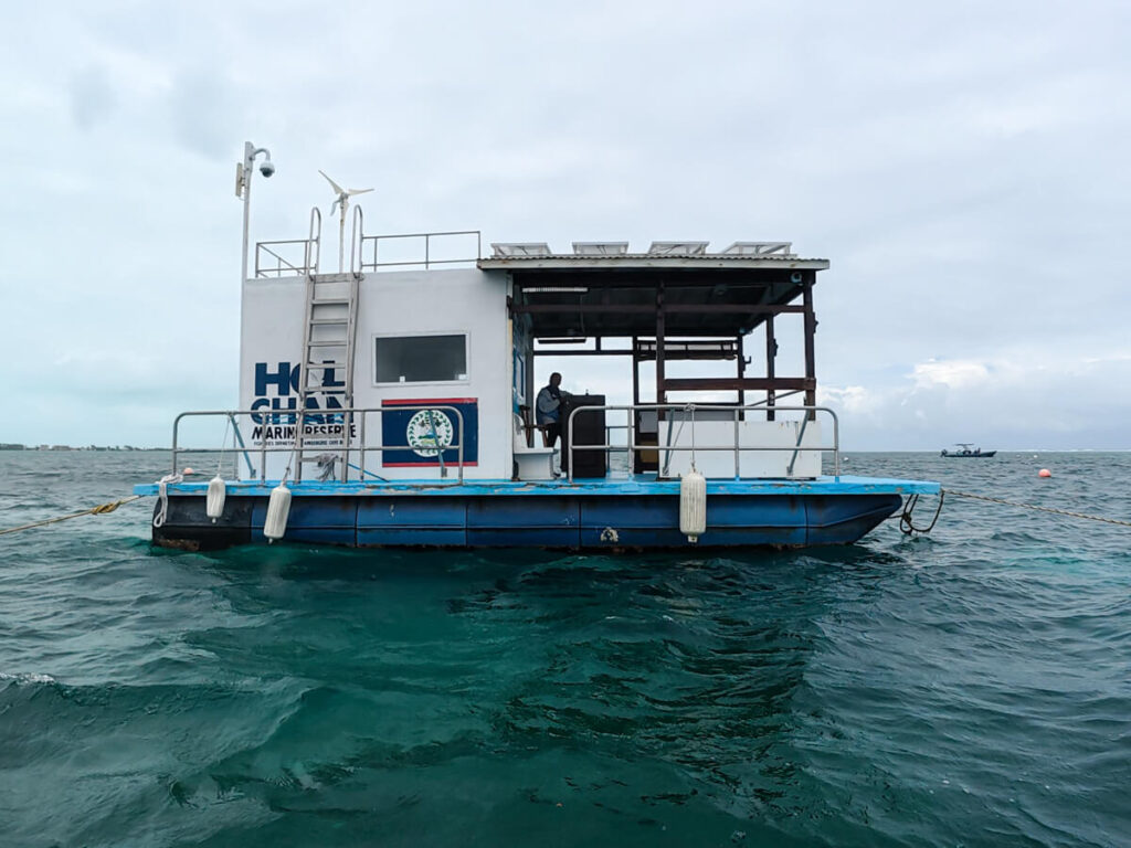 A ranger for the Hol Chan Marine Reserve sat on a small barge, taking note of the visitors to the park.
