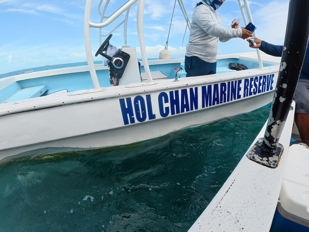 A boat captain showing a Hol Chan Marine Reserve ranger a permit.