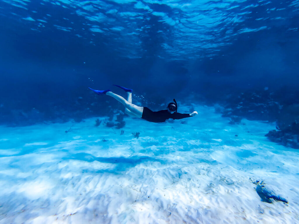 Lucy snorkelling in the clear waters of the Hol Chan Marine Reserve. No other people can be seen in the water.