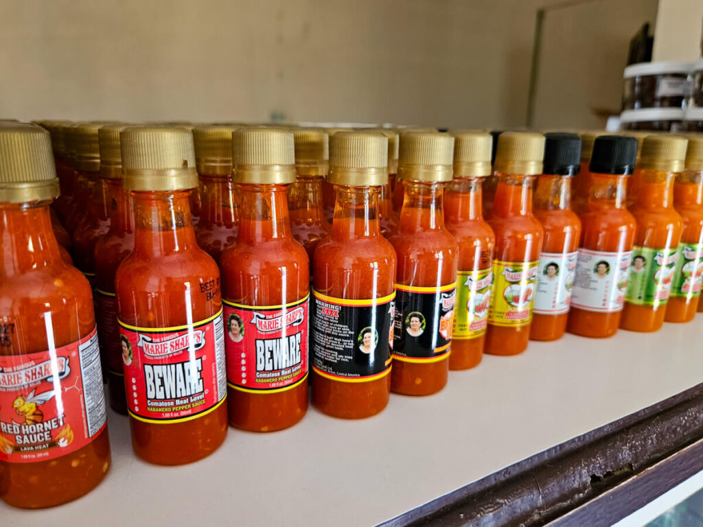 A shop shelf with a selection of Marie Sharp's Hot Sauces.