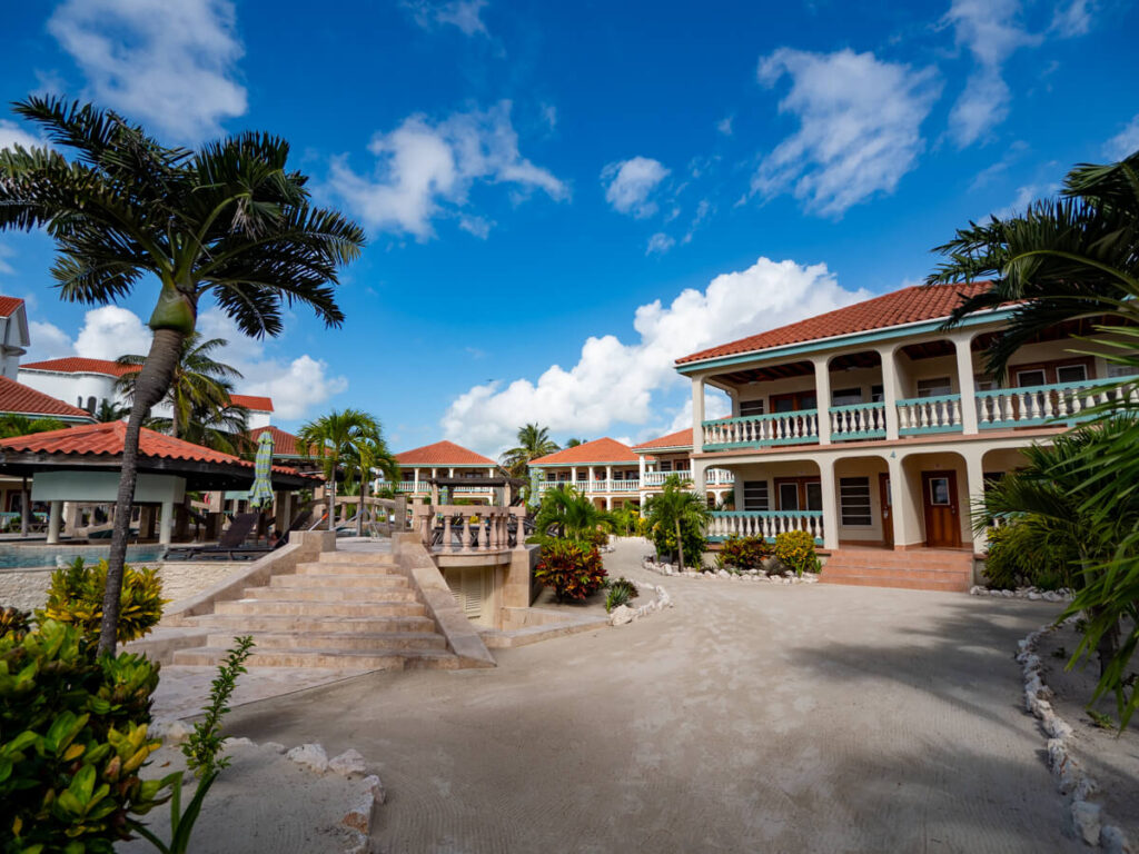 The pool area at Belizean Shores Resort. Sandy pathways lead to different suites, and marble steps lead to the pool.