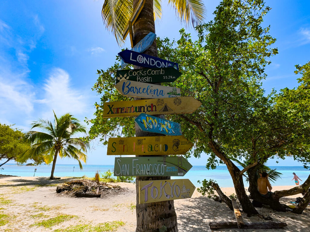 A signpost on South Water Caye, pointing to a variety of international cities.