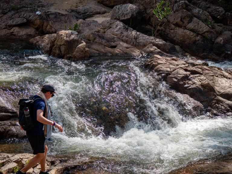 Dan walking in front of the gushing river at Big Rock Falls in the Mountain Pine Ridge Forest Reserve.