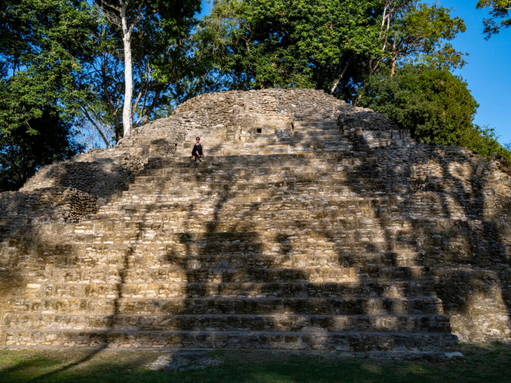 Lucy sitting on the steps of a large pyramid at the Mayan site of Cahal Pech.