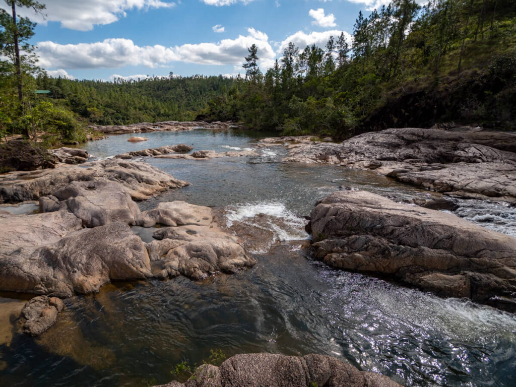 A river winding through boulders in the Mountain Pine Ridge Forest Reserve.
