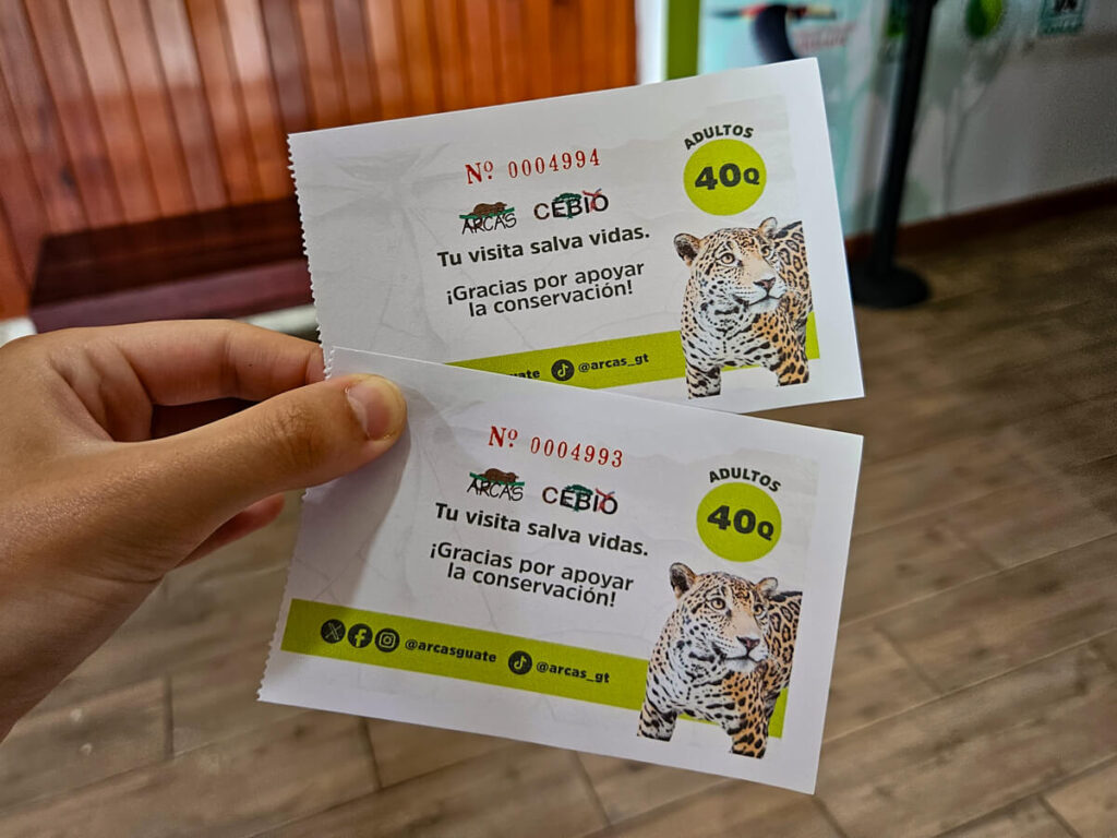 A hand holding two tickets for ARCAS, Guatemala.