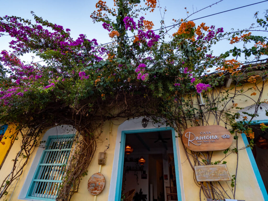 Purple flowers adorning the doorway of the yellow Casa Ramona Hotel in Flores, Guatemala.