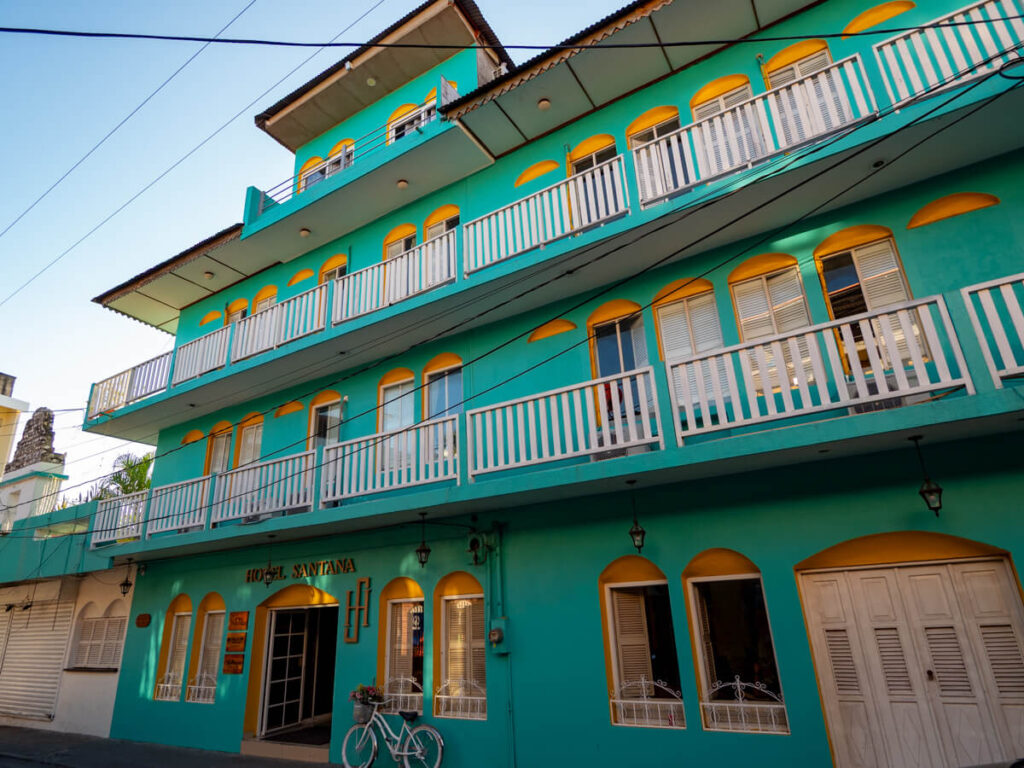 The turquoise and yellow façade of a hotel in Flores, Guatemala.