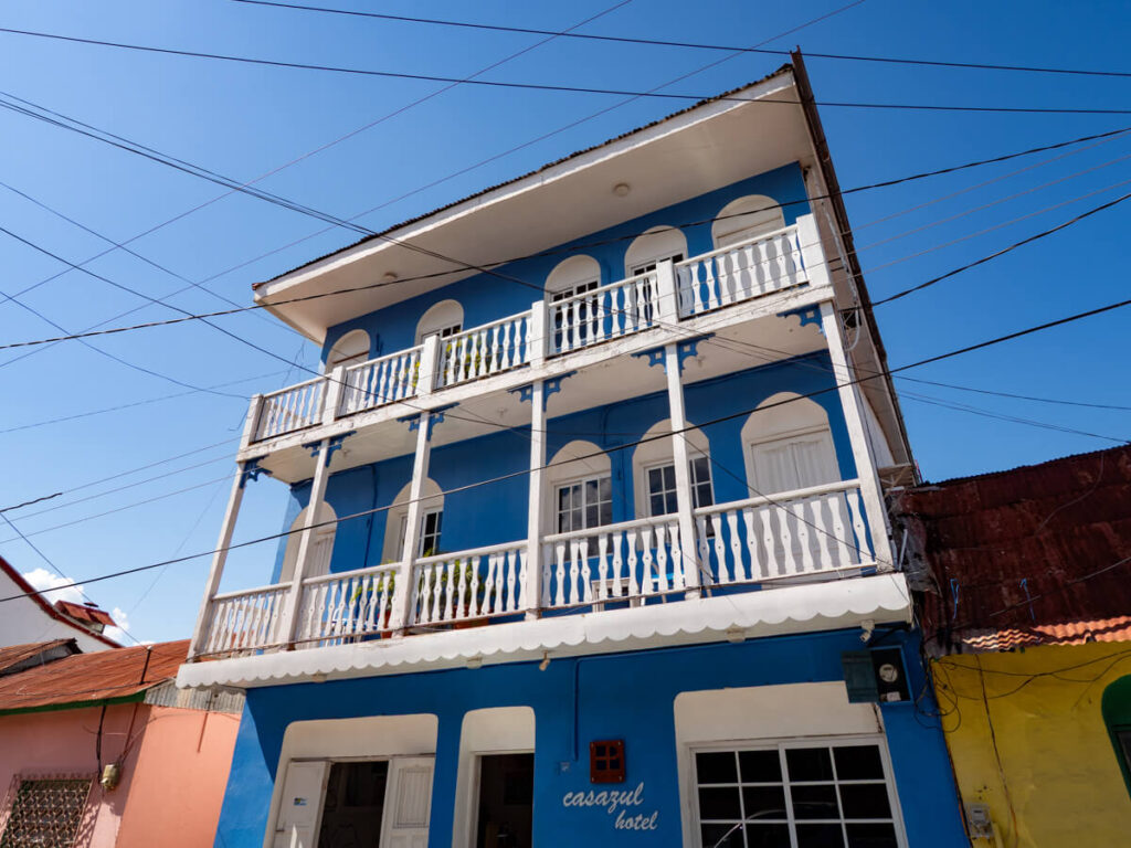 Hotel Casazul's exterior, a blue hotel with white balconies in Isla de Flores, Guatemala.