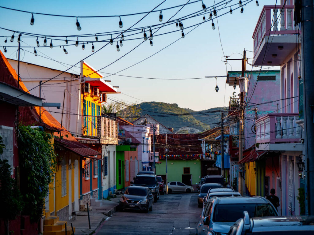 A street in Isla de Flores, Guatemala, lined with colourful houses and twinkling lights.