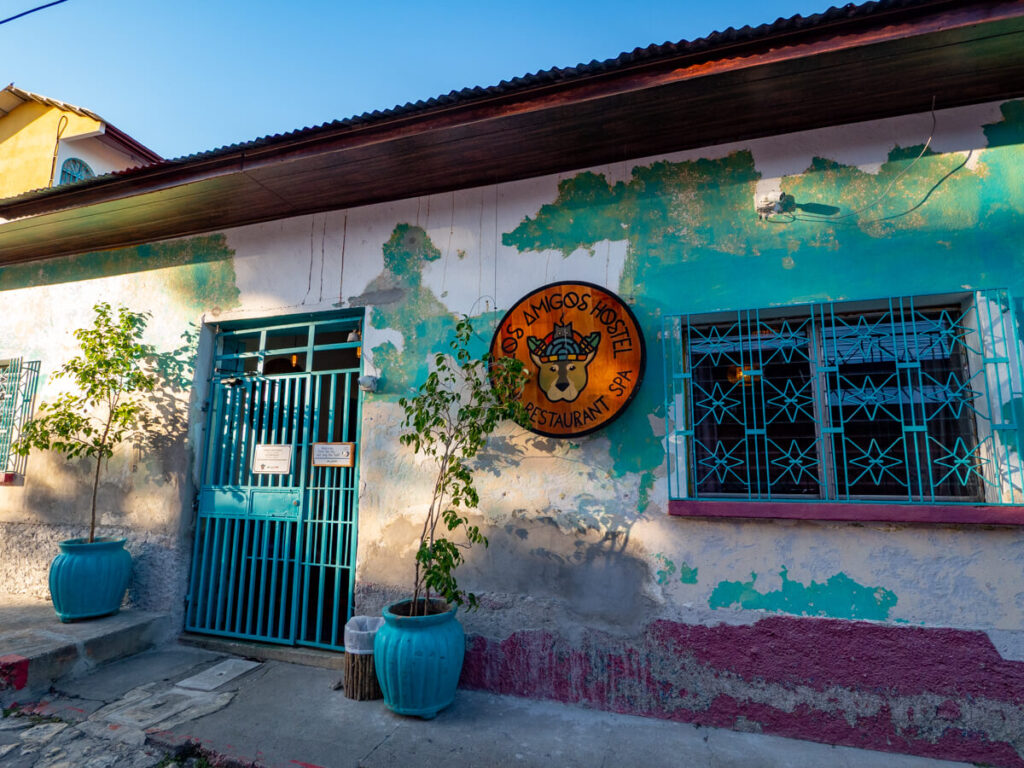 The faded, colourful exterior of Los Amigos Hostel in Flores, Guatemala.