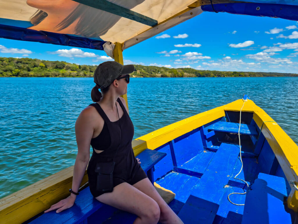 Lucy on a blue and yellow lancha, looking out at Lake Peten Itza in Flores, Guatemala.