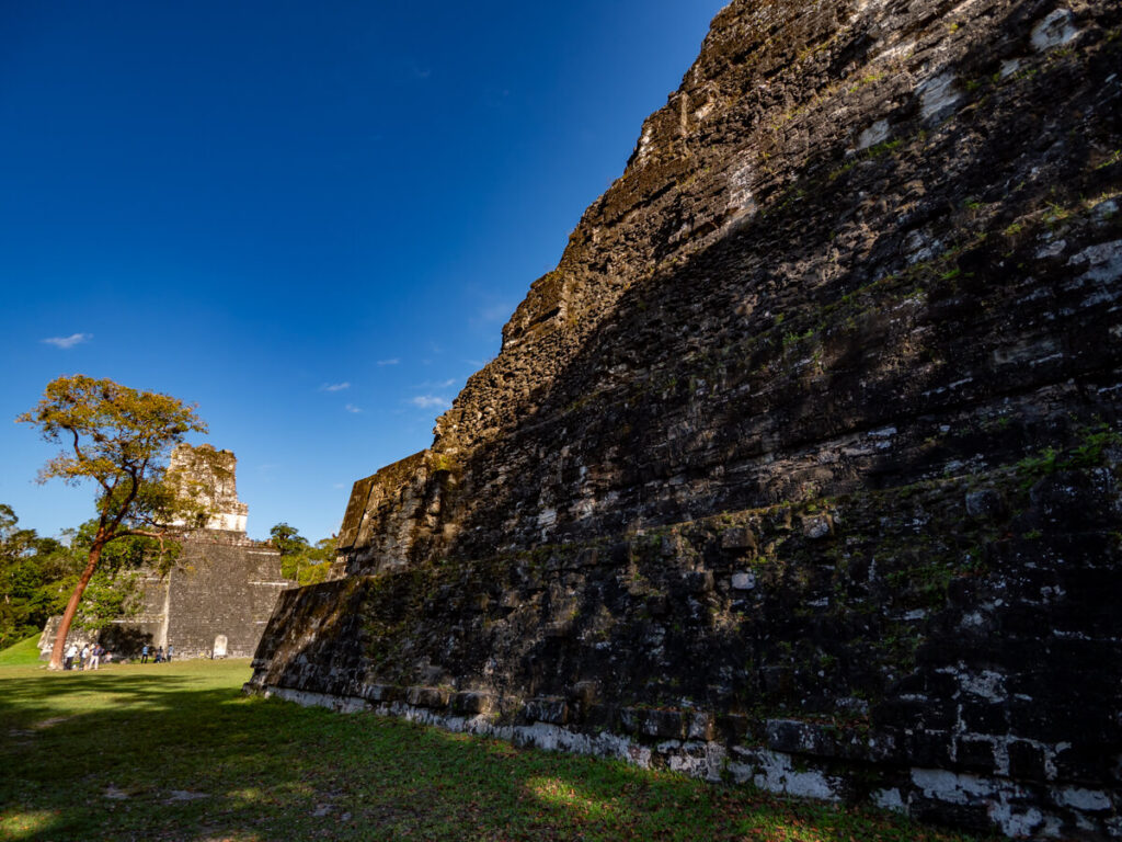 The sun rising over grand Mayan temples in Tikal.