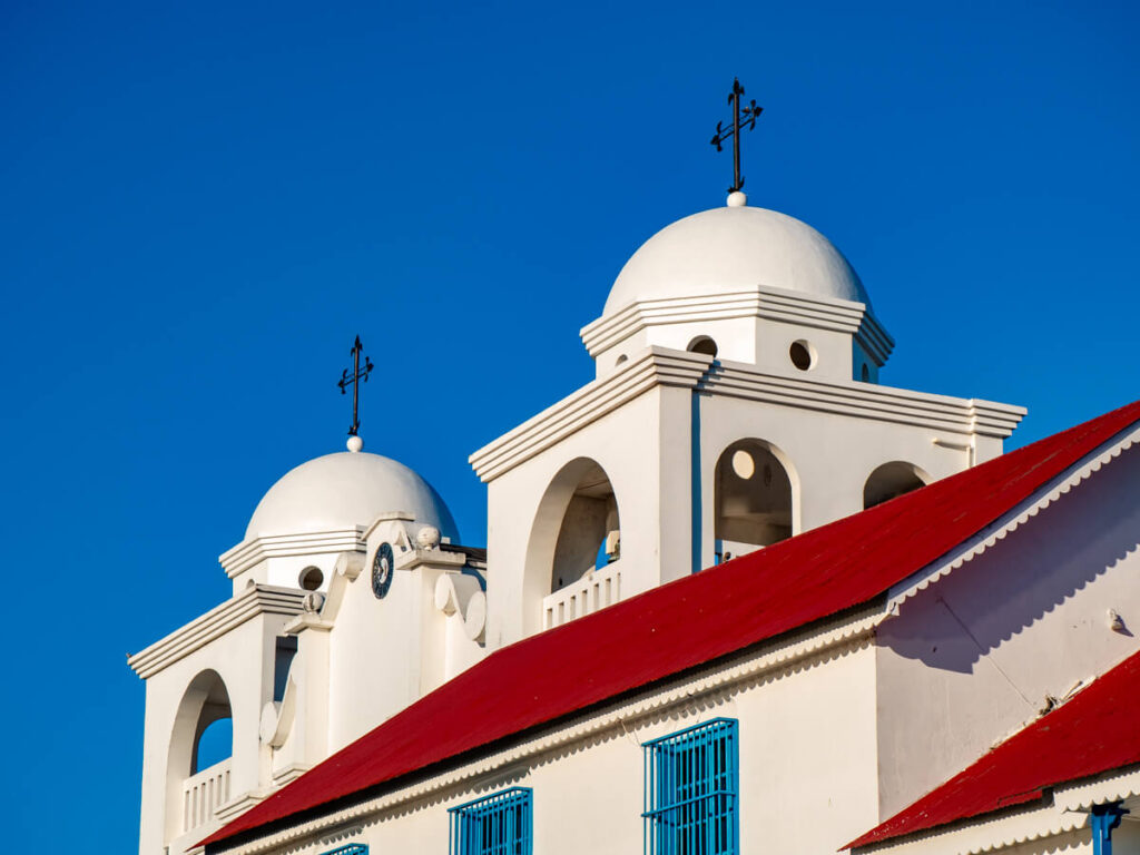 A bright white, domed church roof against a blue sky in Isla de Flores, Guatemala.