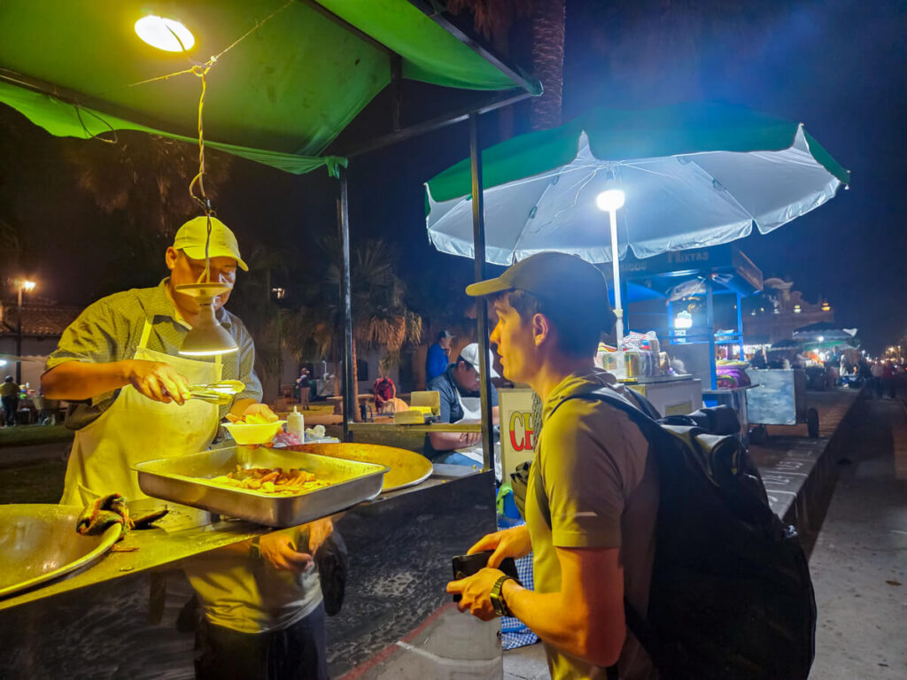 Dan ordering street food at night from a vendor in Antigua, Guatemala.