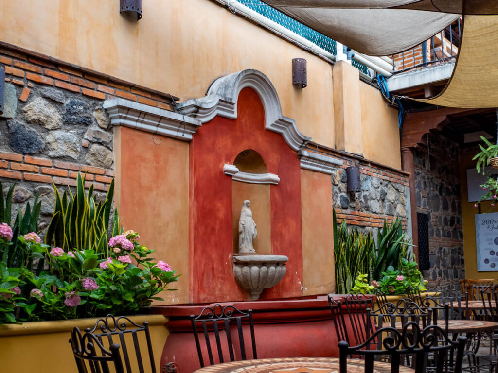The pastel-painted interior of a colonial courtyard in a café in Antigua, Guatemala.