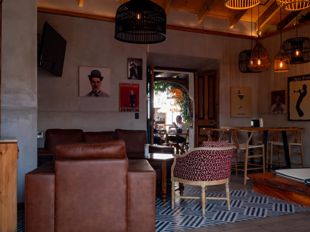 The warmly lit interior of Hector's Bistro, with comfortable 
chairs and art on the walls, one of the top restaurants in Antigua, Guatemala.