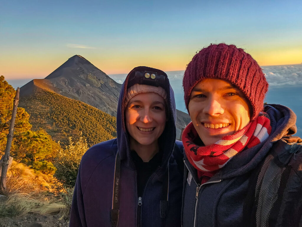 Lucy and Dan wrapped up warm on Acatenango Volcano as the sun sets on the impressive Fuego Volcano behind them.
