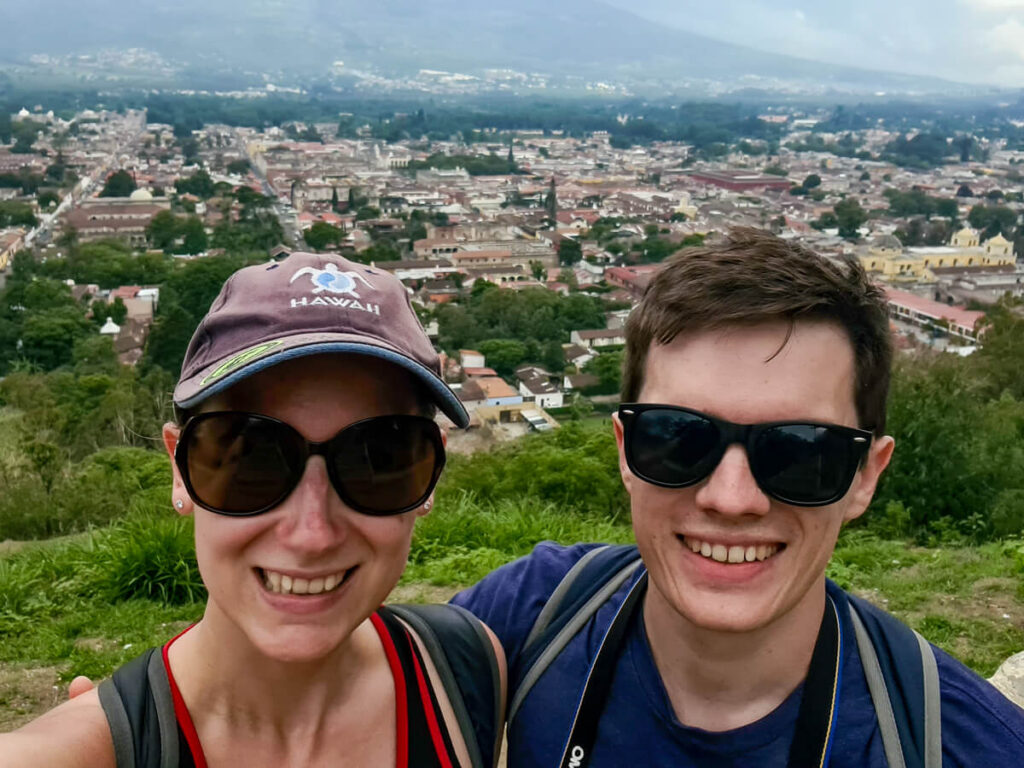 Lucy and Dan smiling in front of Antigua at the Cerro de la Cruz viewpoint.