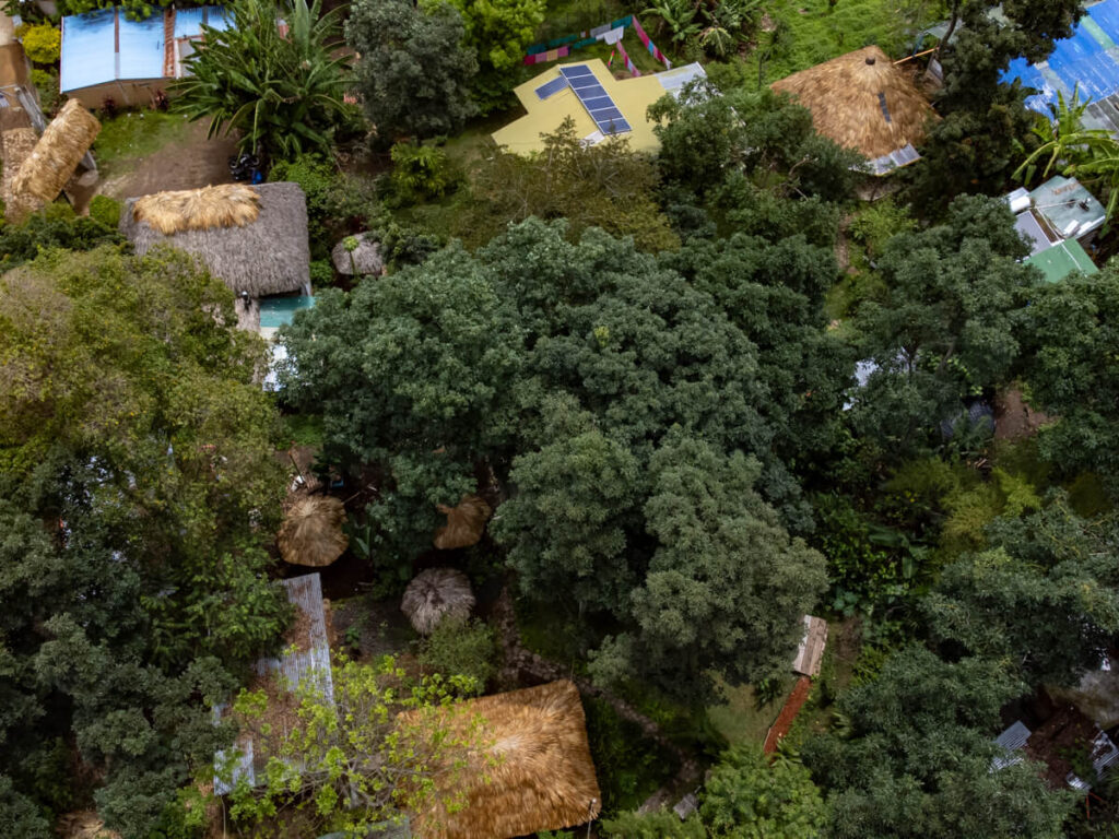 A drone shot of bungalows among lush greenery in Eco-Hotel Mayachik´ in San Juan La Laguna, Lake Atitlán.