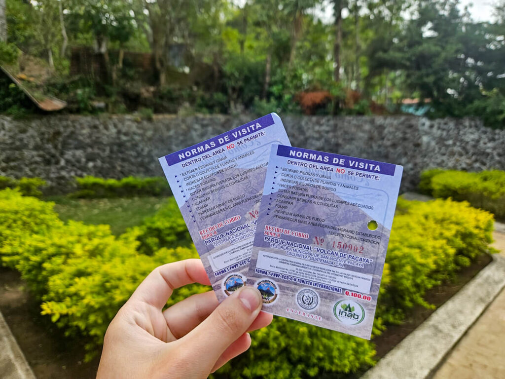 A hand holding two tickets for Pacaya Volcano National Park.