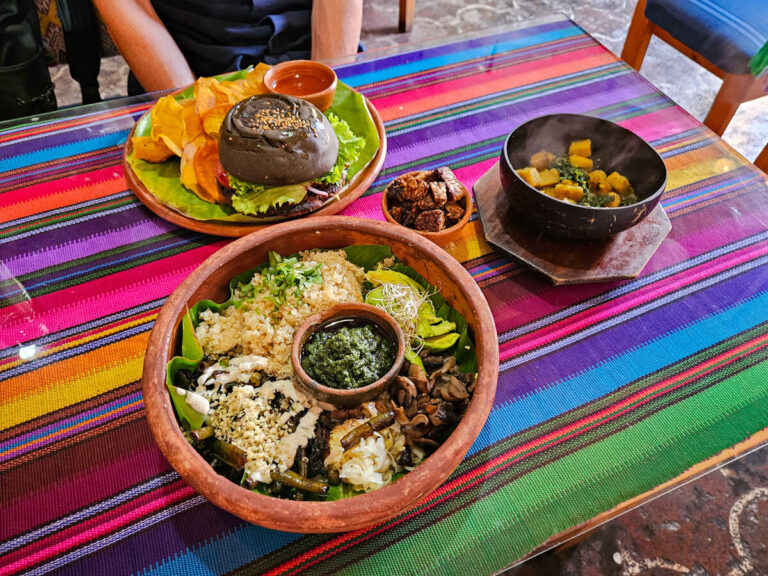 Bowls of delicious vegan food on a colourful table cloth in Wachuma, one of the best restaurants in Antigua, Guatemala.
