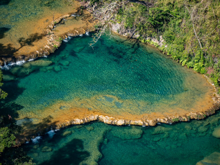 A large limestone pool with crystal-clear, turquoise water in Semuc Champey, Guatemala.