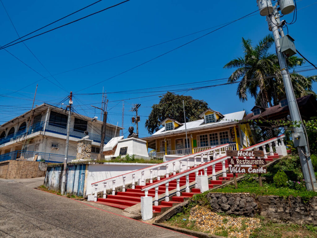 The grand entrance of a red staircase to the Hotel Villa Caribe in Livingston.