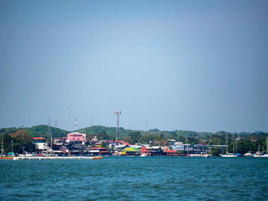 Colourful buildings of Río Dulce town lining a wide river in Guatemala.