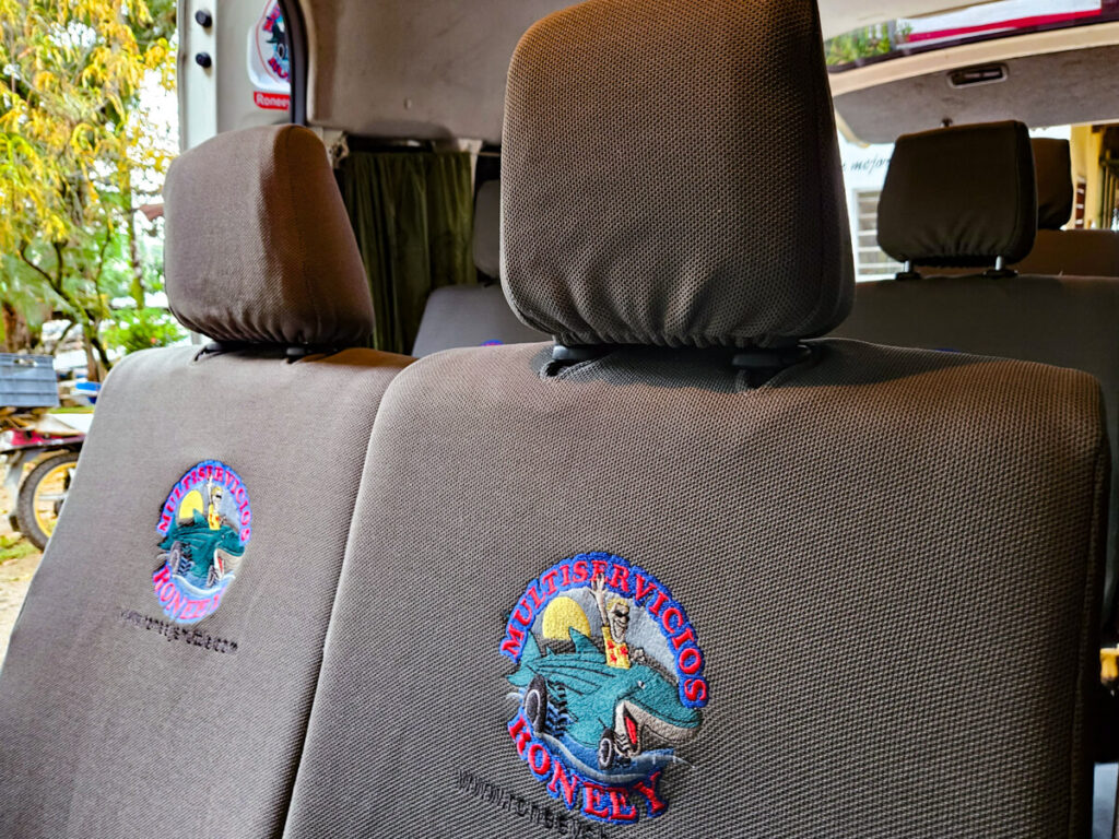 Seats with a logo for Rooney Shuttle in a minibus, one of the top ways to get around Central America.