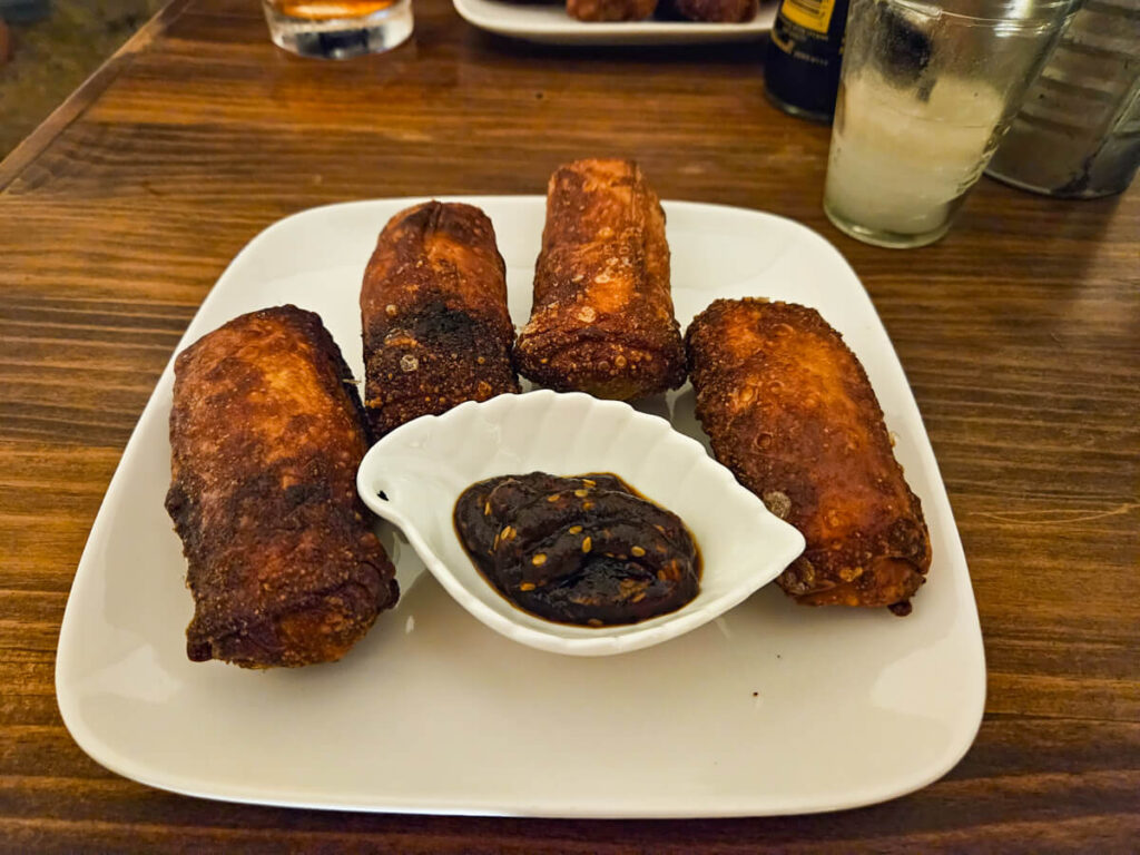 A plate of four spring rolls and a dip in Naoko Woks & Sushi Paredón.