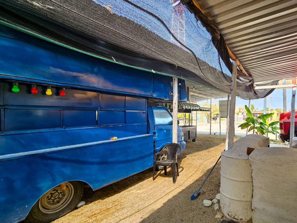 A large blue bus decorated in colourful lights serving as a taco stand in El Paredón, Guatemala.