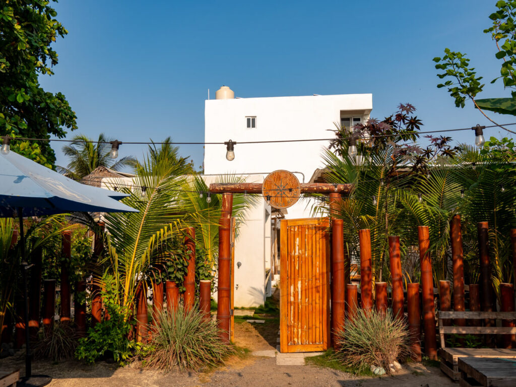 A wooden gate leading to the whitewashed Wander Boutique Hotel in El Paredón.