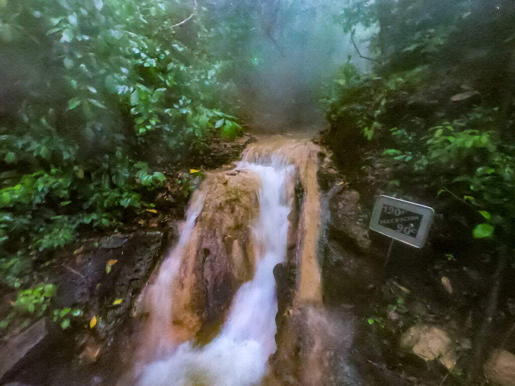 A waterfall cascading into a hot river in the natural hot springs, Luna Jaguar Spa in Copán Ruinas, Honduras.