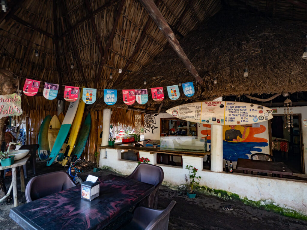 The cosy interior of Yoli's Local Cuisine decorated with surfboards, a Guatemalan restaurant in El Paredón.