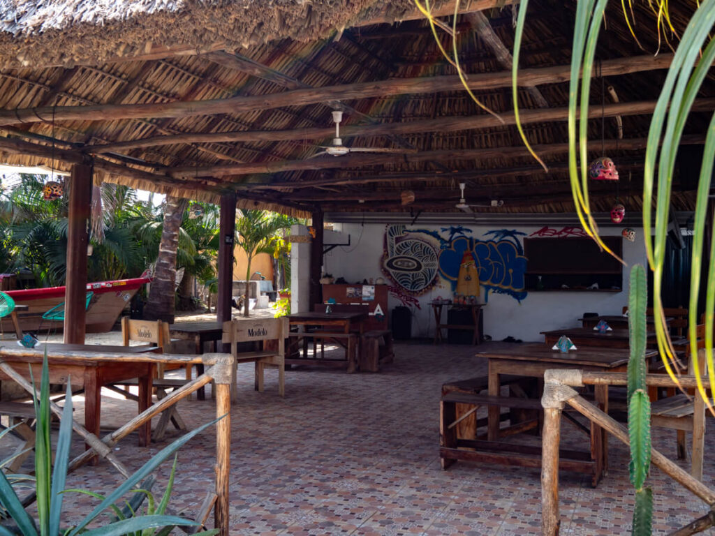 Seating in a restaurants in El Paredón, with a wooden cover and paintings on the walls.
