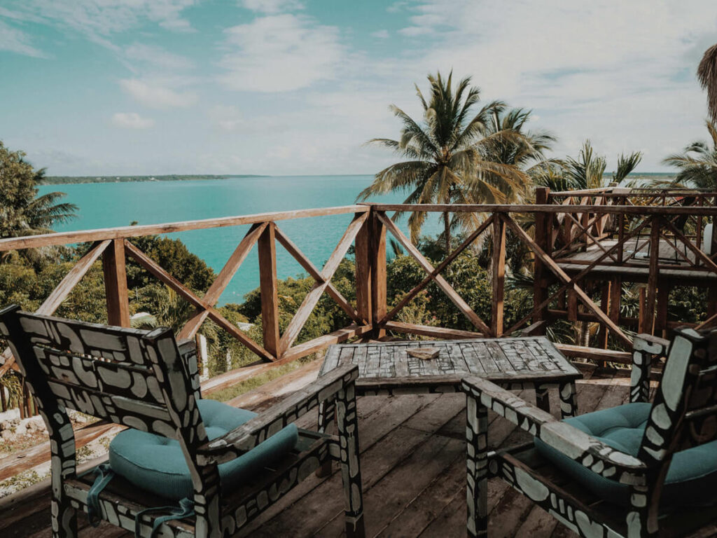 Chairs on a wooden deck overlooking Bacalar Lagoon in BoaBoa Bacalar Hotel.
