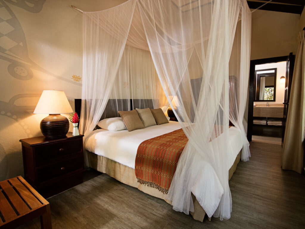 A luxury hotel room with a four poster bed in Jungle Lodge Hotel in Tikal National Park.