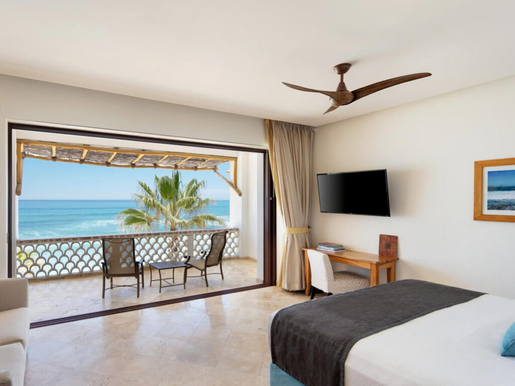 A modern and airy room in Cabo Surf Hotel & Spa, featuring a balcony with ocean views.
