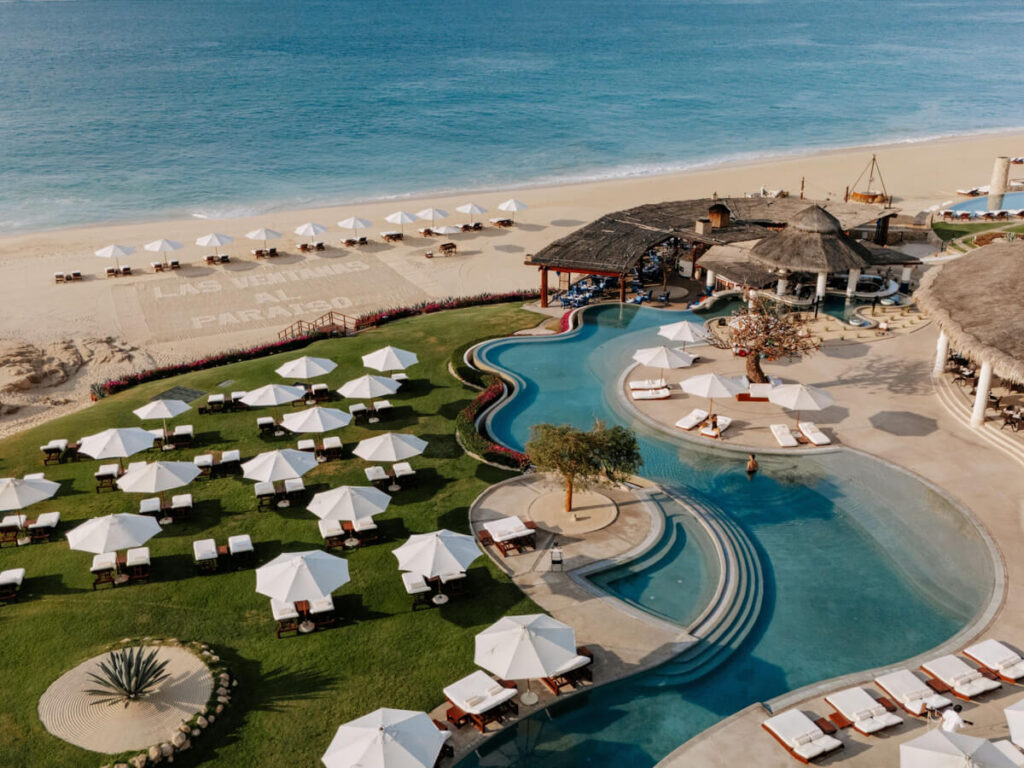Umbrellas surrounding a pool with sea views at Las Ventanas al ParaĂso, A Rosewood Resort, one of the best beachfront hotels in Cabo.