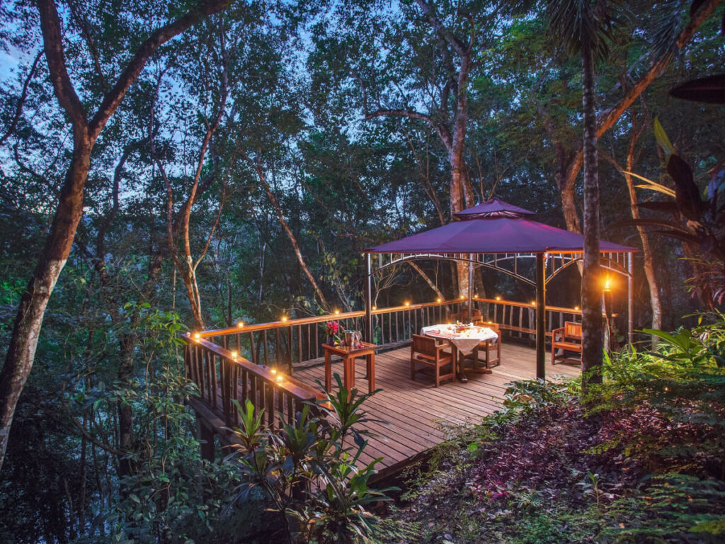 A softly lit veranda overlooking the rainforest at Table Rock Jungle Lodge in Belize.