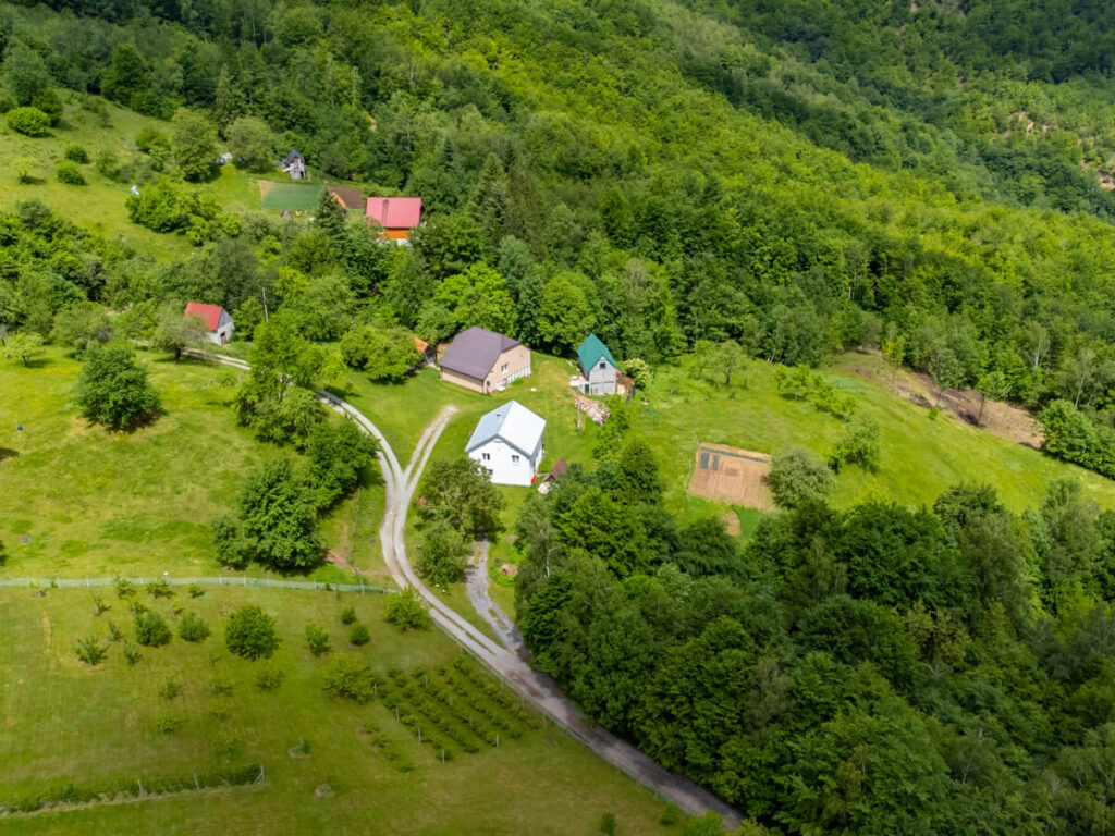 Houses on a grassy hillside outside Biogradska Gora National Park.