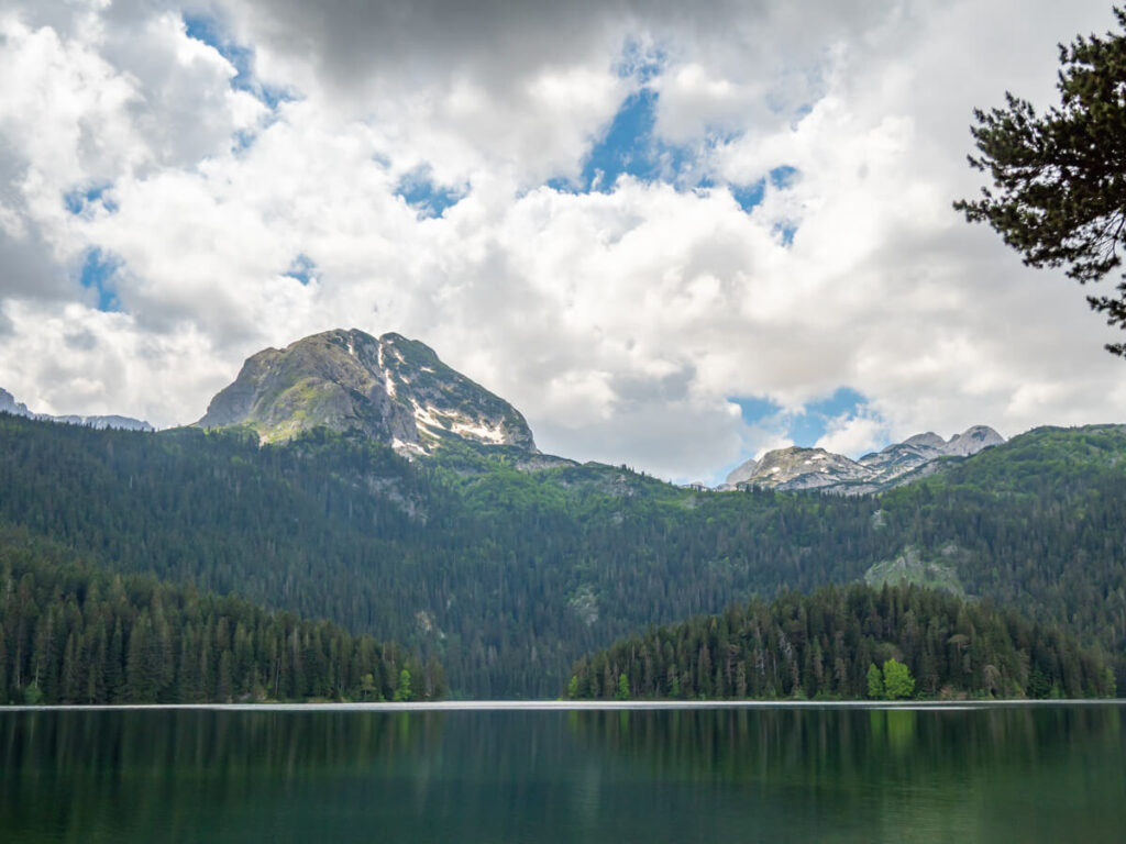 The moody Black Lake dominated by a limestone peak and backed by forest near Žabljak.