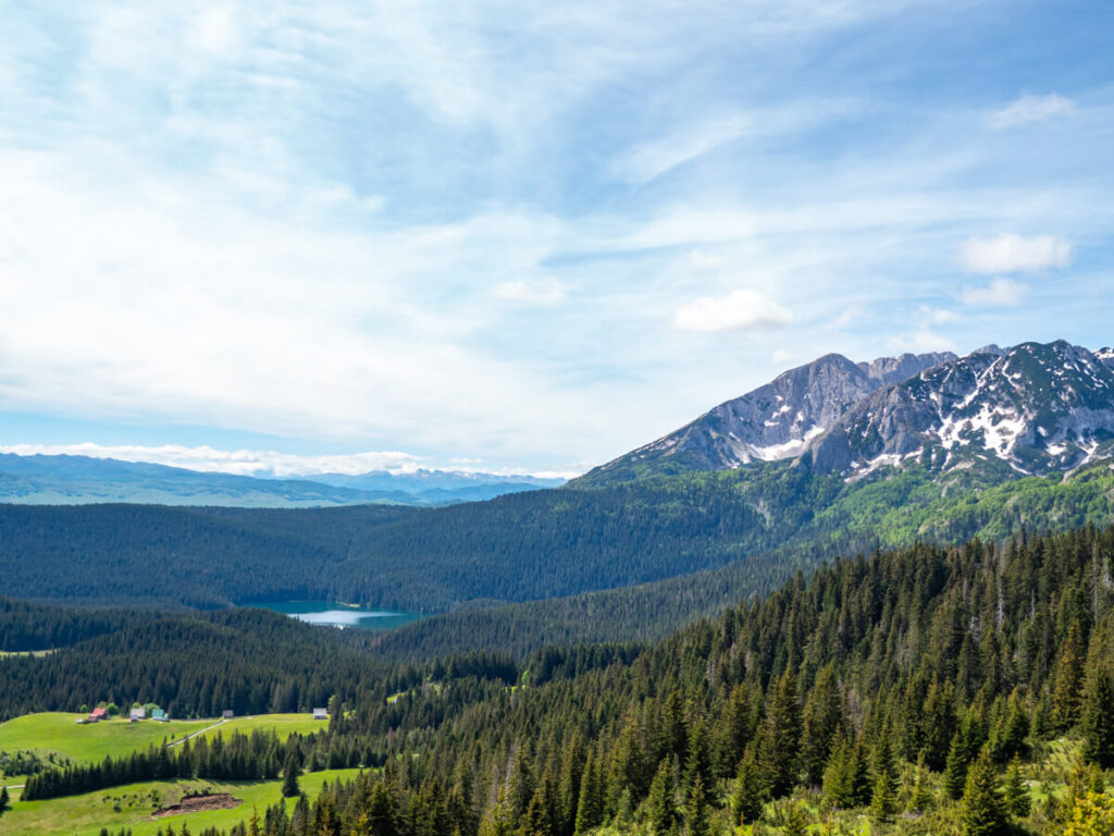 A wide view of the Black Lake in a valley below an imposing peak in Durmitor National Park.