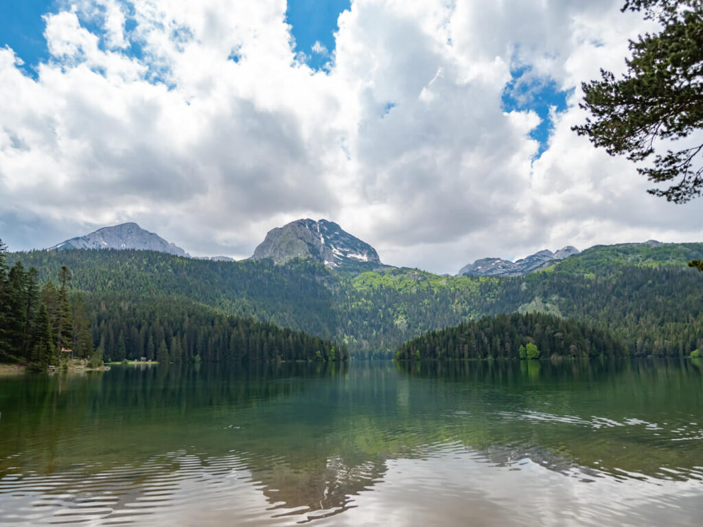 The dramatic Black Lake in Durmitor National Park dominated by a mountain and lined with trees.