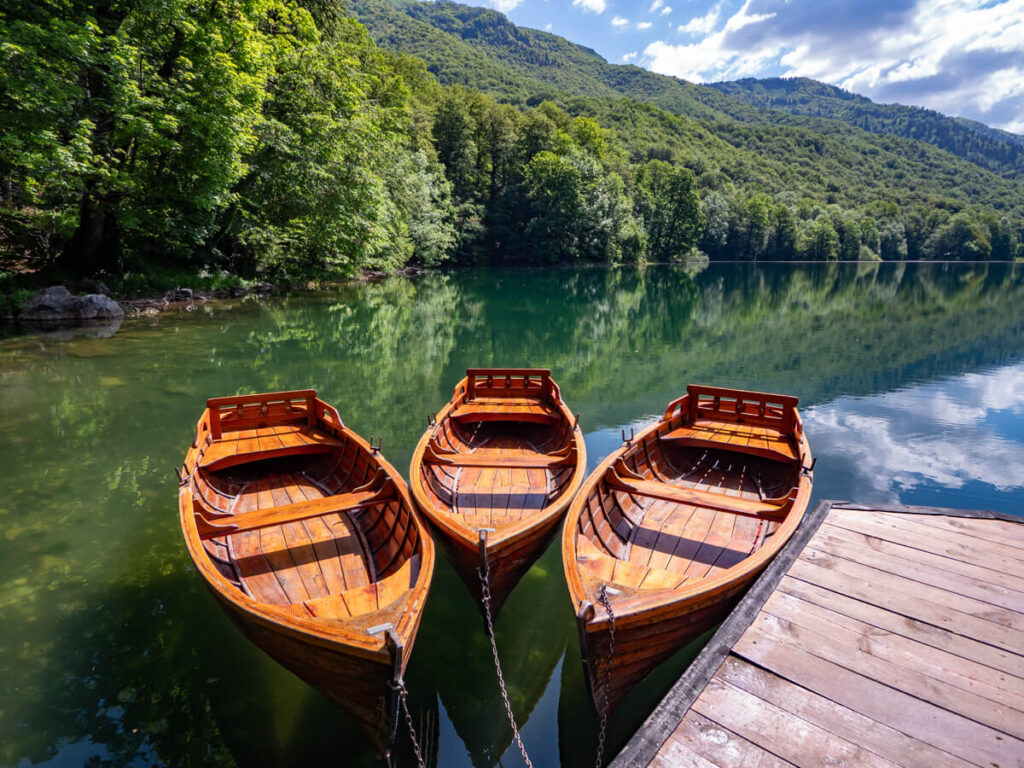 Three wooden boats moored on a dock at Lake Biograd in Biogradska Gora National Park.